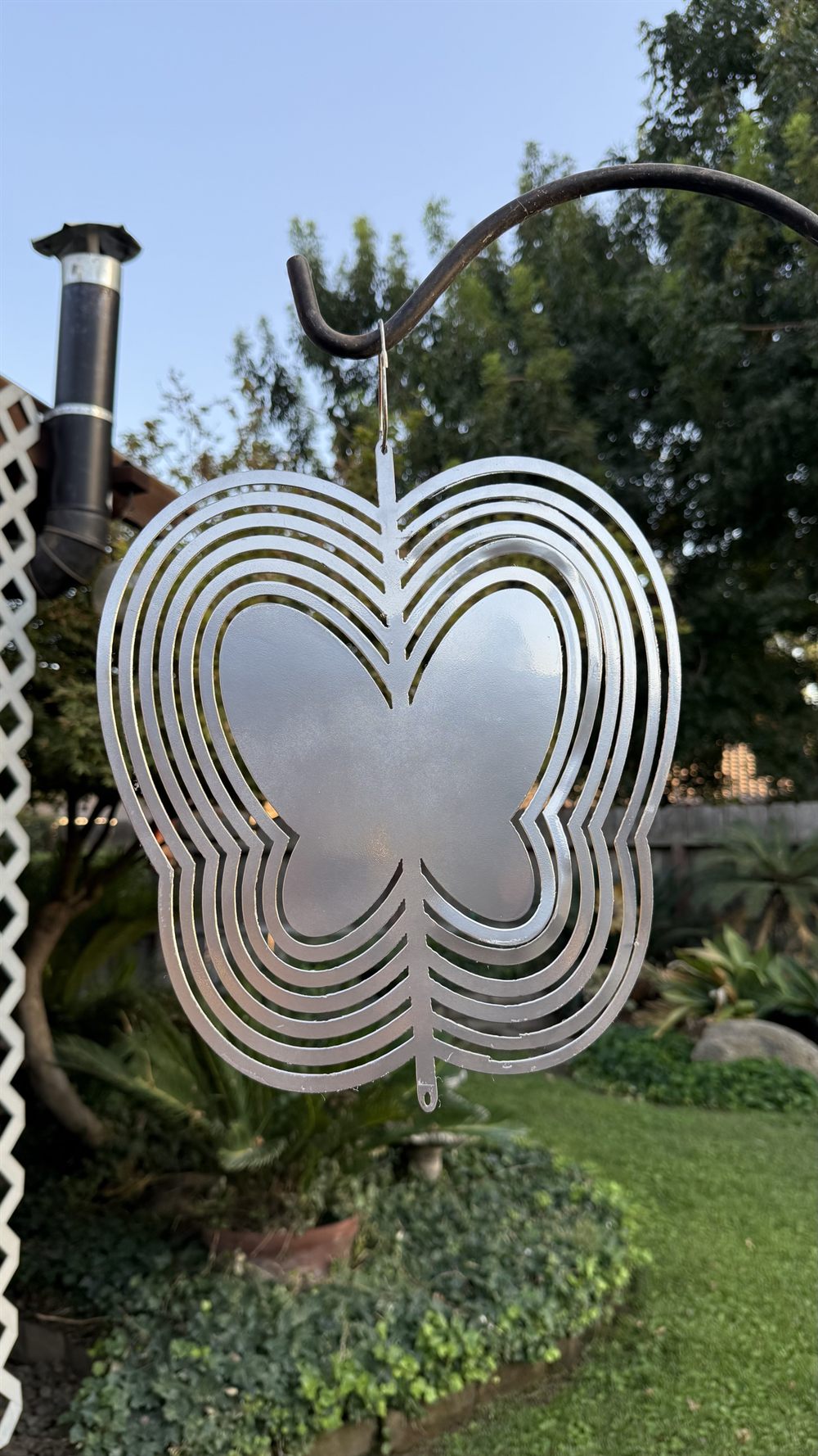 A steel butterfly wind spinner inside a spinning sphere.