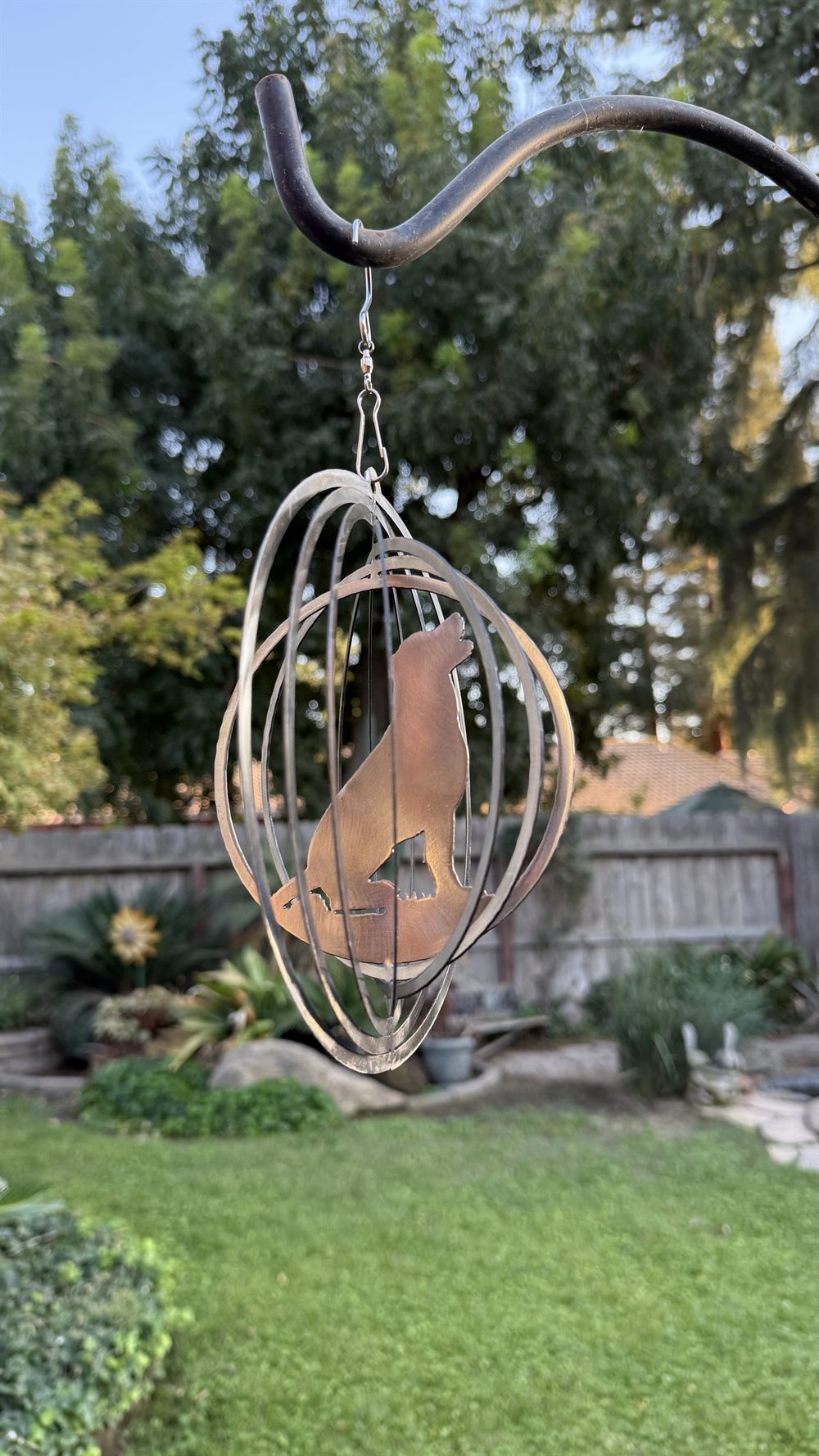 A steel dog wind spinner inside a spinning sphere.