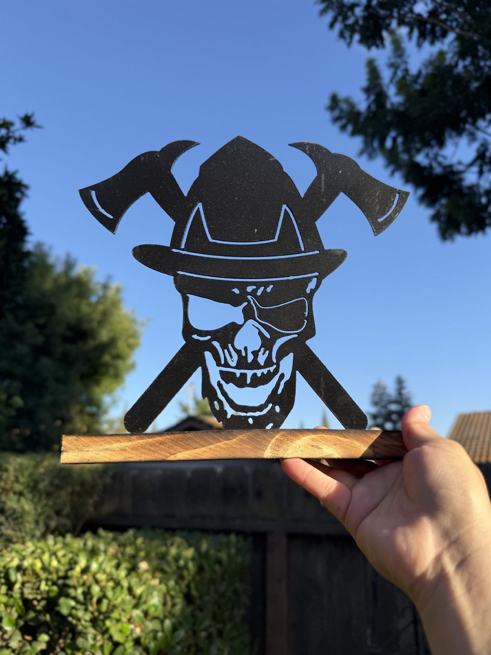 A steel skull in a firefighter helmet with crossed axes.