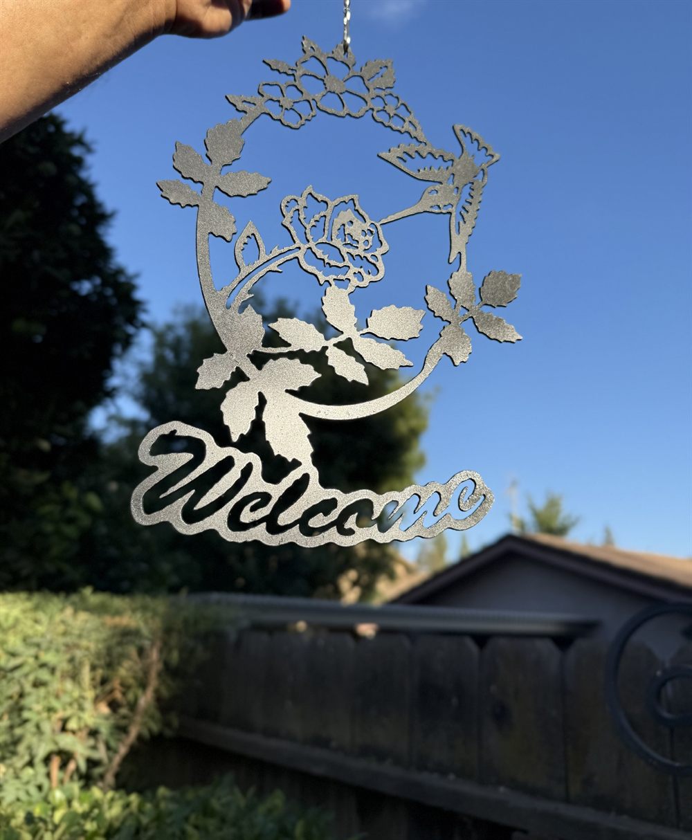 A steel Welcome sign with roses.