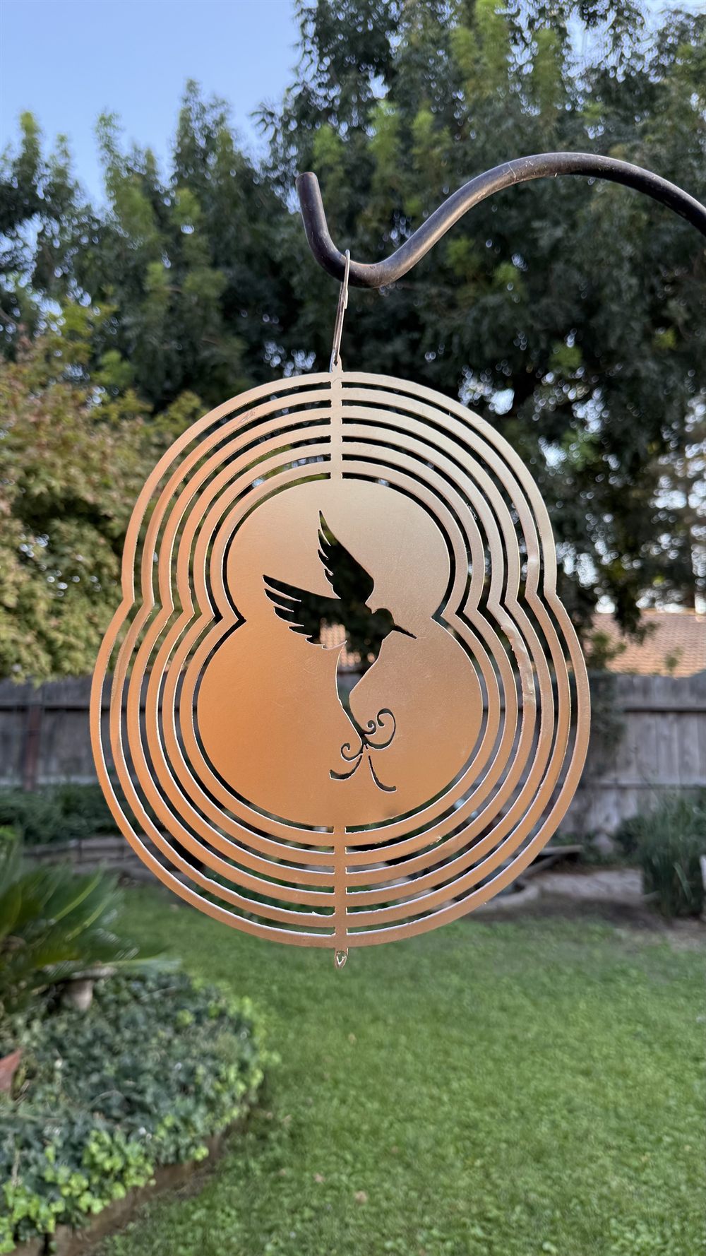 A steel hummingbird wind spinner inside a spinning sphere.
