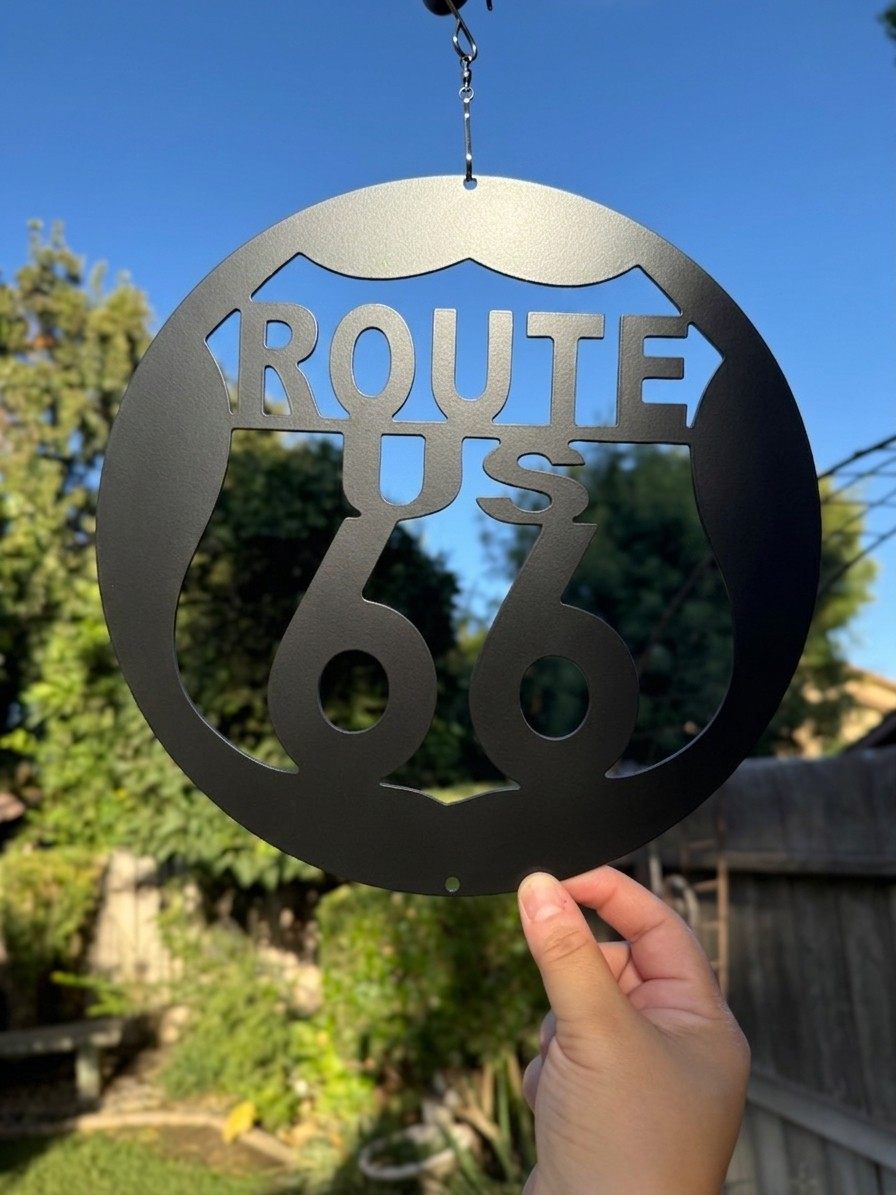 A Route 66 shield cut inside a hanging steel ring.