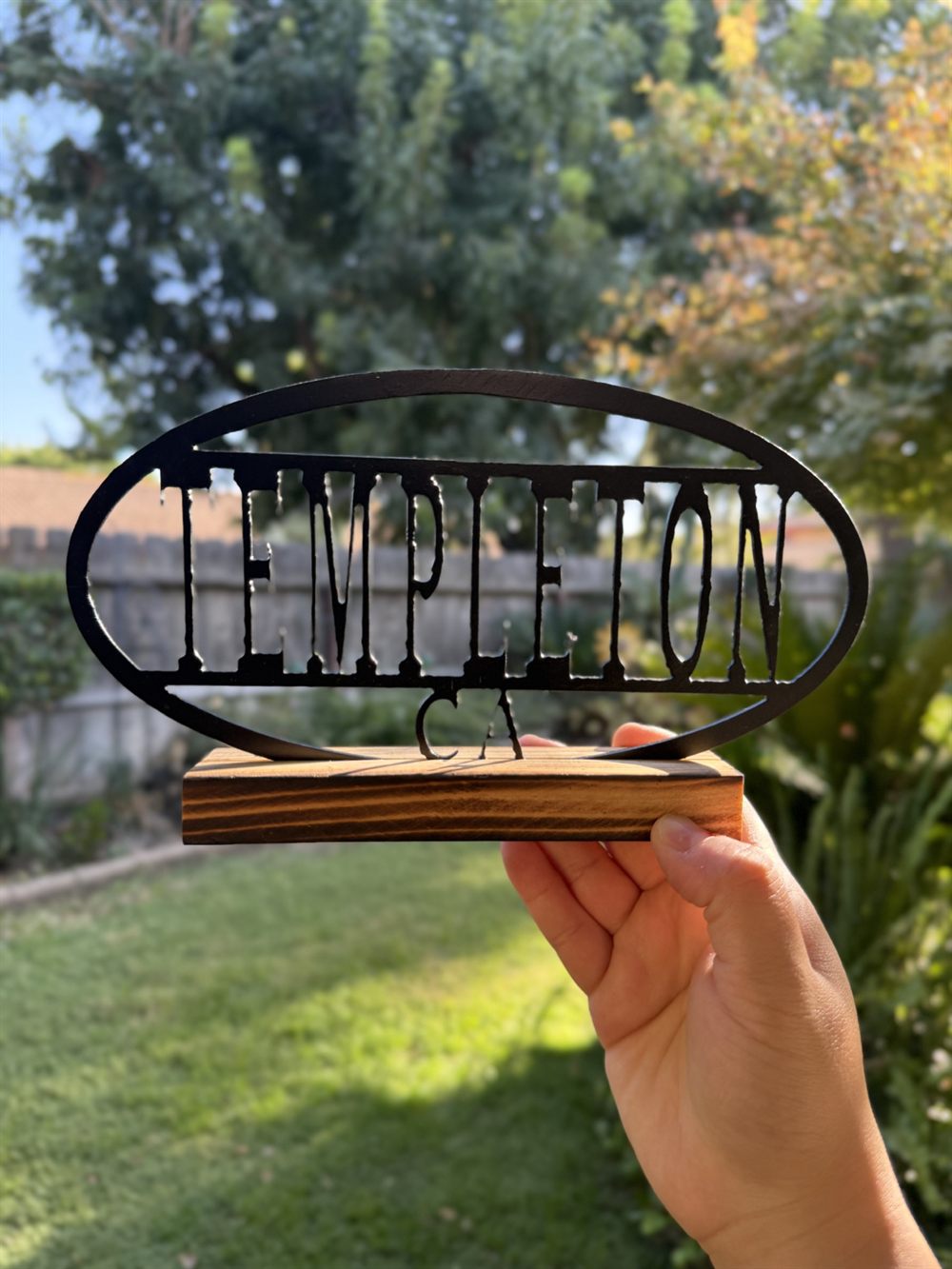 Templeton CA cut inside a steel oval on a wood base.